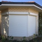 A hosue with a bay window coverd in 3 nu style almond coloured electric roller shutters