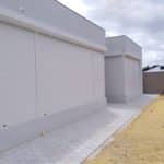 shows a home being protcted by a storm with roller shutters protecting the windows